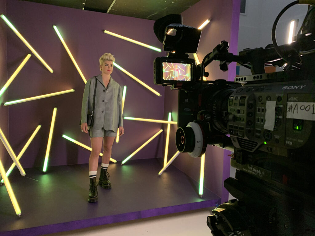 A sony FX9 camera with canon cine prime lens on a TV commercial shoot in Manchester. A model is standing in a purple cube set with neon lights around her